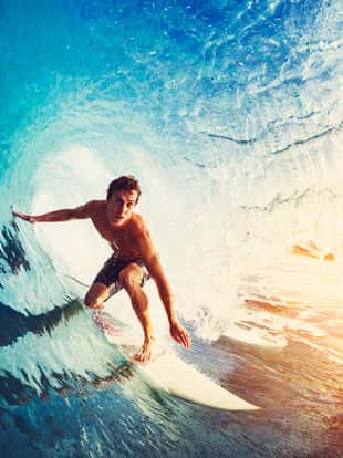 Surfer on Blue Ocean Wave Getting Barreled at Sunrise