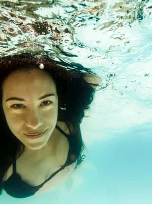 Beautiful woman swimming in clear water