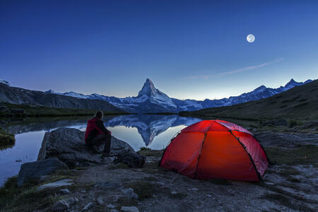 An illuminated tent  under full Moon at Matterhorn in Switzerland