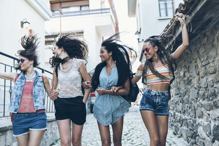 Cheerful young people walking on street and having fun, dancing.