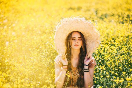 Romantic hippie girl standing in a field. Summer. Hippie style.