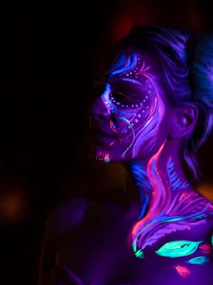 Night portrait of a beautiful girl with fluorescent body paint.