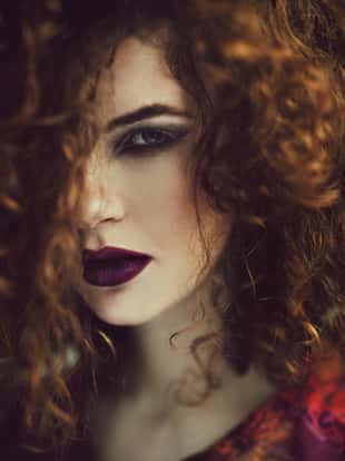 Beautiful caucasian curly redhaired woman posing. Grain added