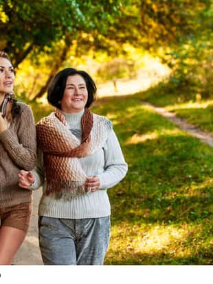 Portrait of young woman with her mom walking in autumn forest
