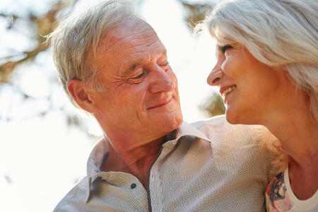 Glückliches Paar Senioren blickt sich verliebt in die Augen im Sommer