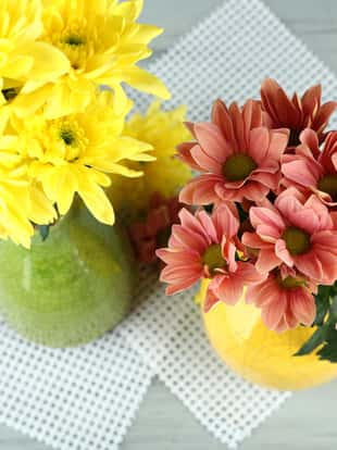 Beautiful flowers  in vases, on wooden table background