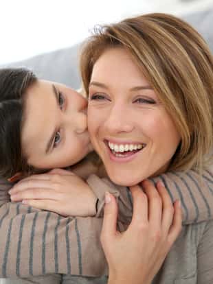 Little girl kissing her mom on cheek