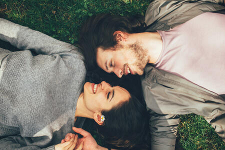 Happy young couple lying on the grass