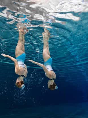 training synchronized swimming siblings in crystal clear water